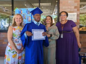 CDC Graduate poses for a photo with his diploma