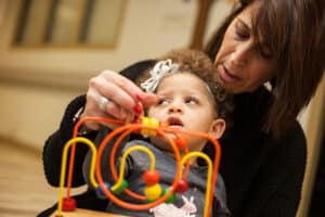 A teacher of the visually impaired works with a young child to feel shapes