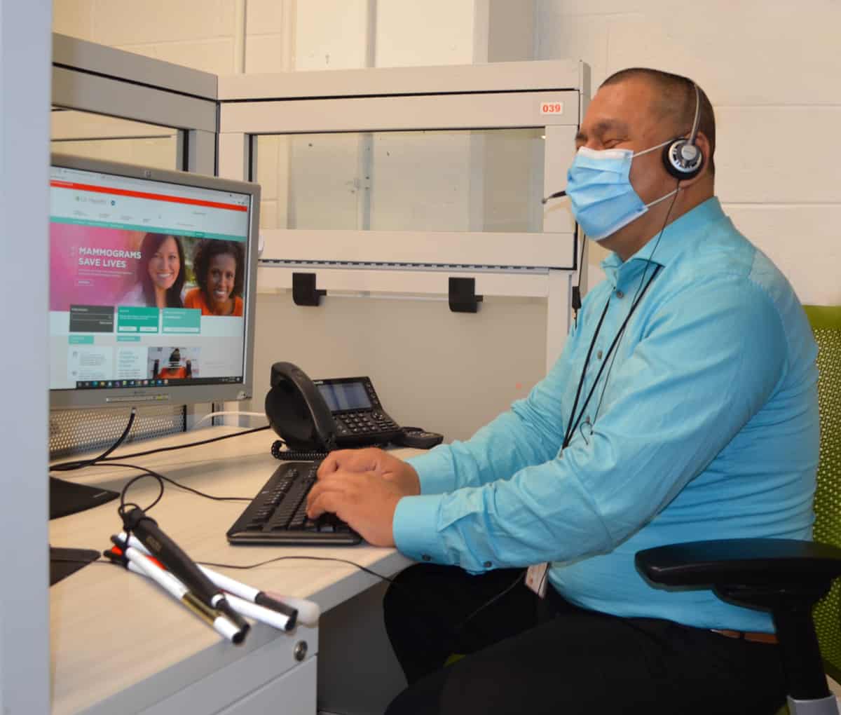 Juan Sitting at his desk helping a caller