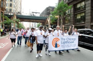 A group of Chicago Lighthouse employees hold a banner and march in the Disability Pride Parade in Chicago