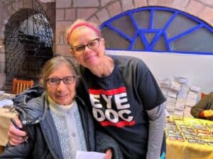 Dr. Matchinski standing with a patient wearing her new glasses in Peru.