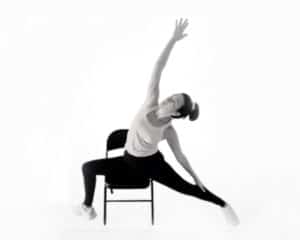 Woman doing a yoga pose sitting on a chair