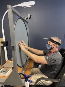 A participant of the ICVP clinical trial points on a circular field to where he is receiving visual feedback via a wireless implant in his brain.