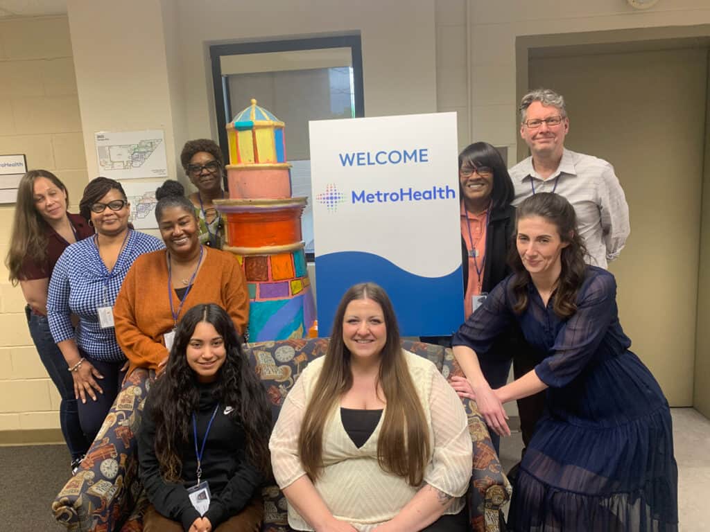 Members of the Metro Health Call center gather around a welcome sign for a picture