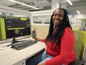 Twilla Green Sitting at her desk smiling for the Camera