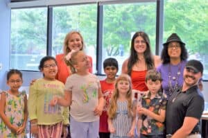 Lighthouse president and CEO Dr. Janet Szlyk poses for a photo with six young children from the BELL program and three adult teachers. They are all standing together and smiling for the camera.