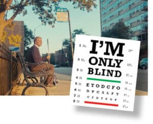 Photo of a man who is blind sitting at a bus stop. Superimposed over the image is a movie poster in the look of an eye chart that reads: I'm Only Blind