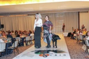 Runway at a fashion show with a model who is blind and her guide dog