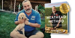 A photo of a man with short hair and a short, grey beard is sitting in a grassy area holding a fluffy beige puppy, next to a cover image of a book titled "The Meathead Method." The book shows the same man, Meathead, grilling on the cover.