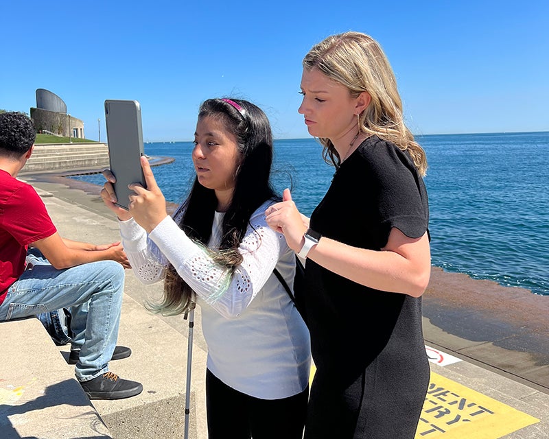 Giselle taking a photo on a sunny day with a guide