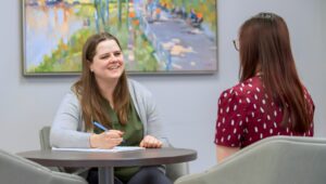 Two women sit and talk during a counseling session.