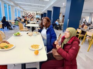 Kalari and Shada smile as they sit in the cafeteria at Loyola, enjoying French fries and good company.