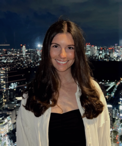Hayley Christine headshot in front of a city skyline at night.